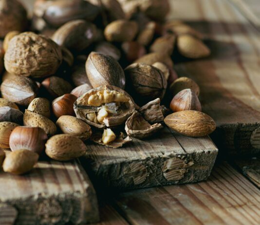 건강한 몸을 위한 다이어트와 운동의 상호 보완적인 효과 a pile of nuts sitting on top of a wooden cutting board