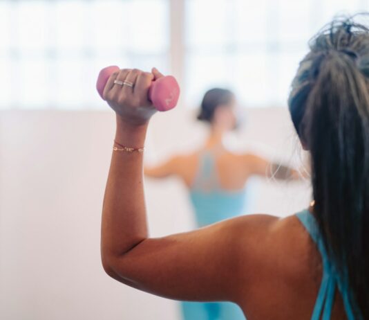 팔 통증 완화 운동법: 필라테스로 건강한 팔 만들기 woman in blue tank top holding pink dumbbell