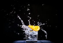 면역력을 높이는 슈퍼푸드와 운동 루틴 splash of water in drinking glass with sliced lemon