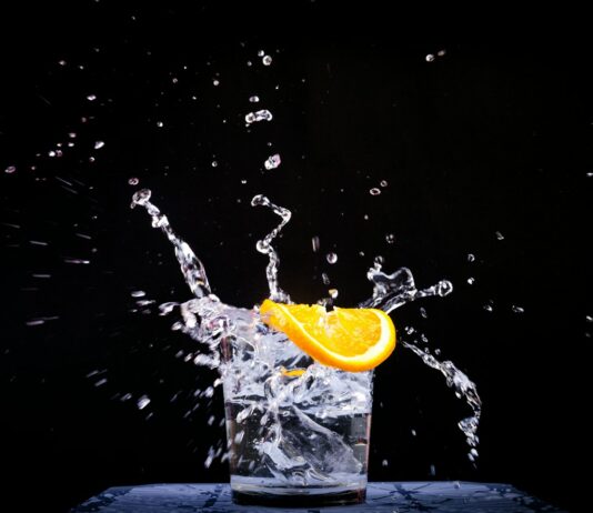 면역력을 높이는 슈퍼푸드와 운동 루틴 splash of water in drinking glass with sliced lemon
