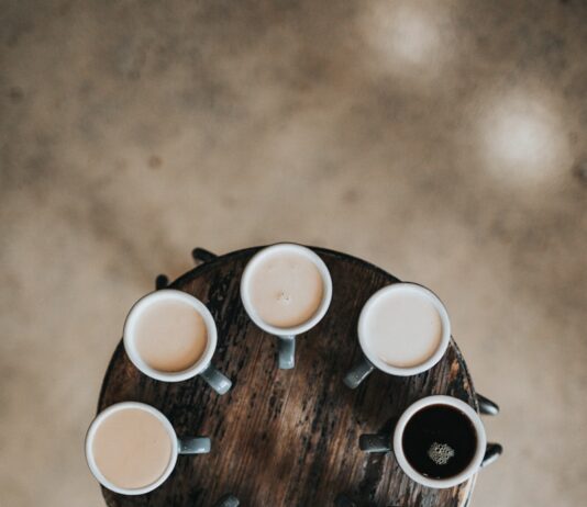건강을 위해 피해야 할 나쁜 습관 flat lay photography of eight coffee latte in mugs on round table