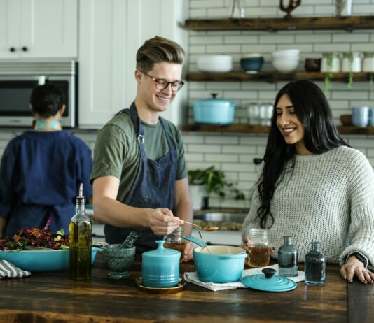 건강한 식습관, 가정에서부터 실천하기 smiling man standing and mixing near woman in kitchen area of the house
