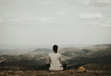 디지털 디톡스와 마인드풀니스, 일상에서 실천하는 정신건강 지키기 woman sitting on cliff overlooking mountains during daytime