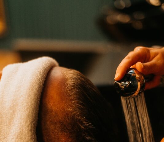 “건강한 모발 관리, 일상 속 작은 습관에서 시작하세요” a man getting his hair washed in a sink