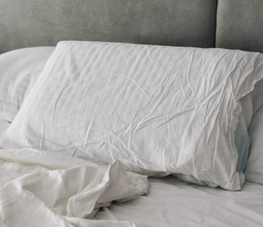 꿀잠을 위한 새로운 루틴, 수면 건강 트렌드와 실천법 A rumpled white duvet and pillows on a bed.