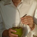 웰니스 문화, 일상에서 시작하는 건강한 변화 person in white button up shirt holding clear drinking glass with green liquid