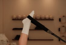 집과 일상 속으로 들어온 필라테스, 건강 트렌드의 새로운 중심 Woman does pilates exercise on a reformer machine.