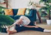 아침 루틴, 건강을 바꾸다… “작은 습관부터 시작하세요” Woman stretching on floor in a living room.