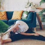 아침 루틴, 건강을 바꾸다… “작은 습관부터 시작하세요” Woman stretching on floor in a living room.